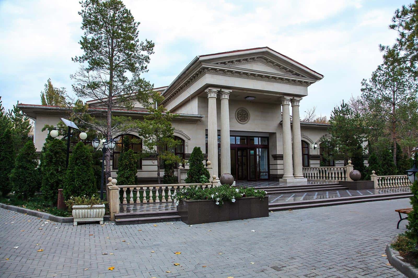 Columned building among pines at the 8 Lakes resort near Almaty — group transfer by Toyota Hiace minibus