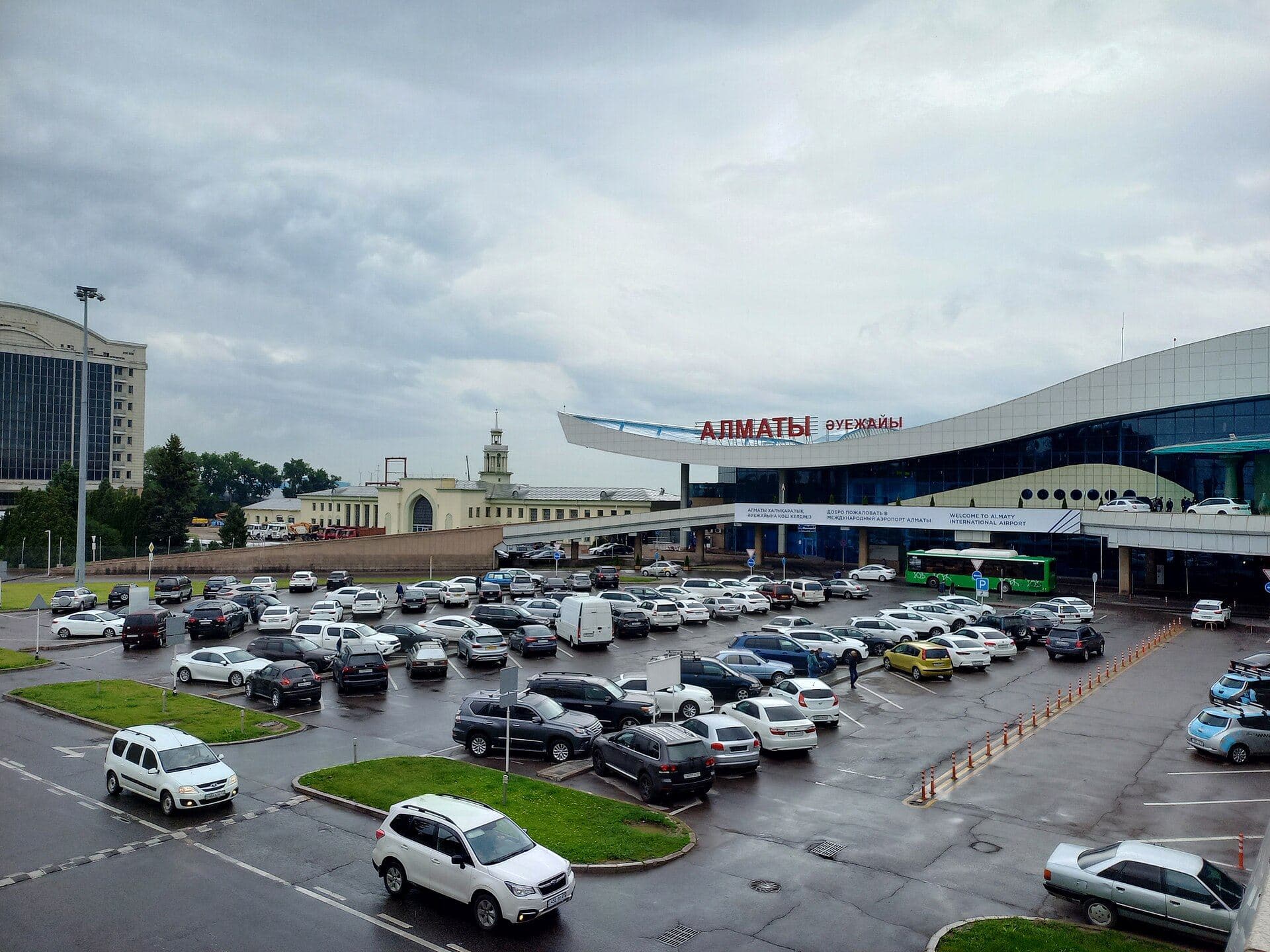Almaty airport terminal and the parking lot in front — airport transfer: taxi or minibus for a group