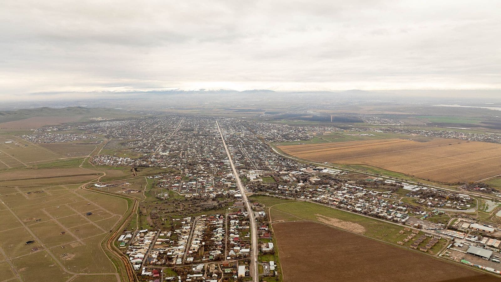 Kordai from above and the highway to the Kyrgyz border checkpoint — minibus transfer from Almaty
