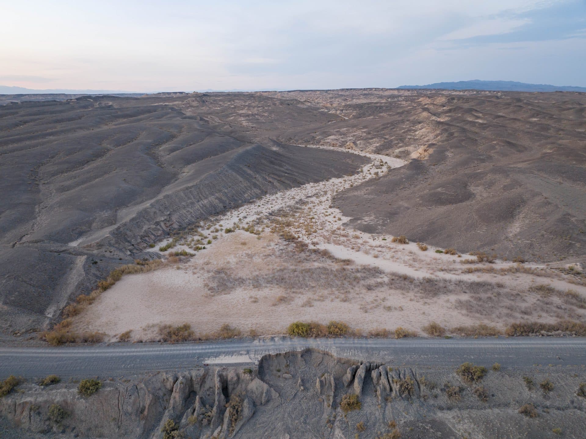 A road through semi-desert hills in the Uyghur District of Almaty Region, home to the Chundzha hot springs — aerial view